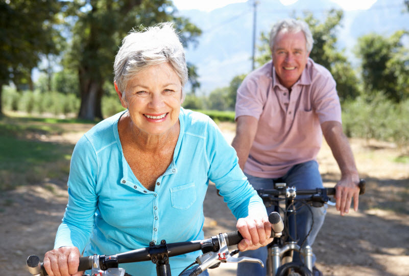 Happy senior couples cycling together
